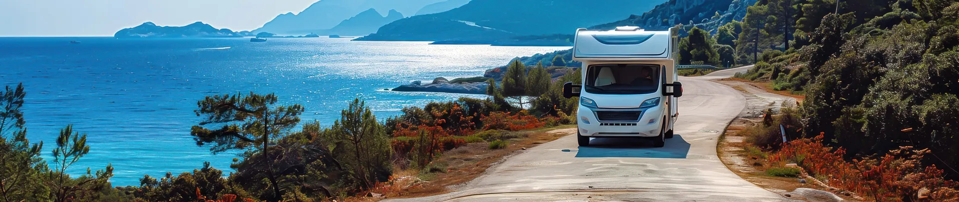 Een camper op een mooi weggetje in een land met bergen en mooi weer