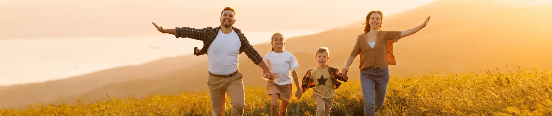 Gelukkige familie aan het rennen bij zonsondergang