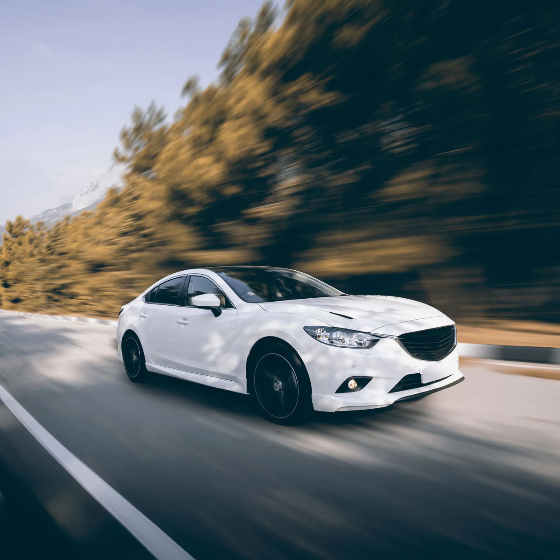 Witte auto rijdt overdat op een asfaltweg